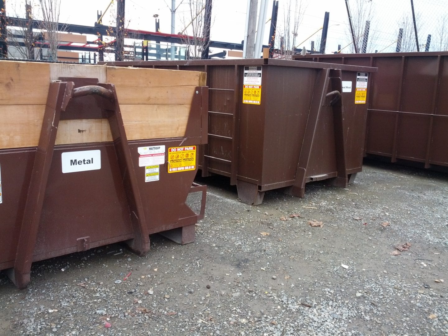 Brown recycling containers labeled for metal and wood disposal, emphasizing eco-friendly waste management solutions for commercial junk removal services in Bellevue.